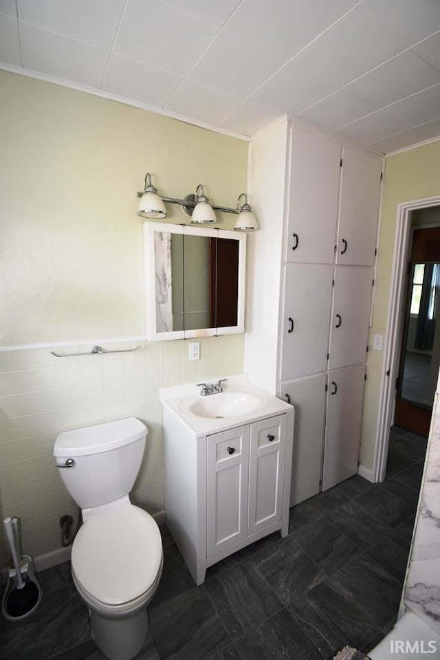 209 E Plum St, Linden, IN 47955 - bathroom featuring vanity, tile walls, ornamental molding, and wainscoting