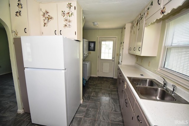 209 E Plum St, Linden, IN 47955 - kitchen featuring freestanding refrigerator, arched walkways, light countertops, stone finish flooring, and white cabinets