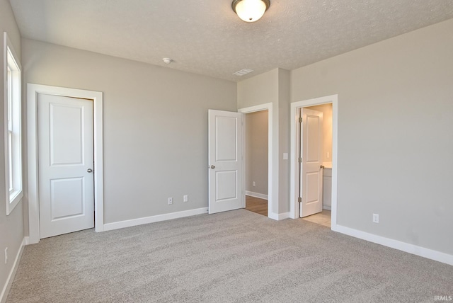 4764 Chelmsford Dr, Newburgh, IN 47630 - unfurnished bedroom with light carpet, a textured ceiling, and connected bathroom