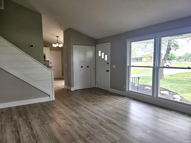 6711 Trier Rd, Fort Wayne, IN 46815 - entryway featuring vaulted ceiling, a chandelier, and wood finished floors