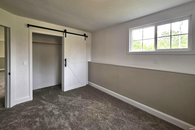 6711 Trier Rd, Fort Wayne, IN 46815 - unfurnished bedroom with a barn door, dark colored carpet, and a closet