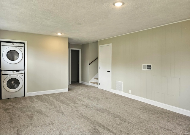 6711 Trier Rd, Fort Wayne, IN 46815 - washroom featuring stacked washing machine and dryer, a textured ceiling, and carpet floors