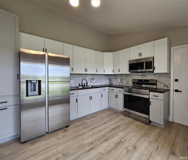 6711 Trier Rd, Fort Wayne, IN 46815 - kitchen with appliances with stainless steel finishes, dark countertops, light wood-style floors, tasteful backsplash, and lofted ceiling