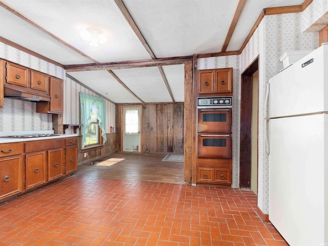 314 N Chauncey St, Columbia City, IN 46725 - kitchen featuring freestanding refrigerator, wallpapered walls, under cabinet range hood, double wall oven, and brown cabinetry