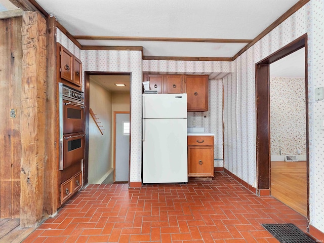 314 N Chauncey St, Columbia City, IN 46725 - kitchen with freestanding refrigerator, wallpapered walls, brown cabinets, double oven, and crown molding