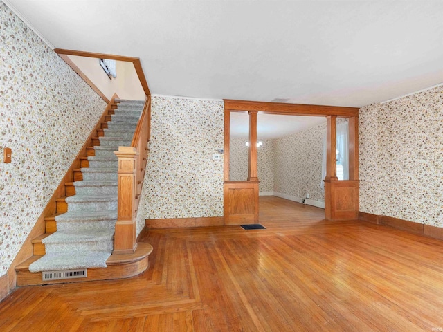 314 N Chauncey St, Columbia City, IN 46725 - stairway with wallpapered walls, wood finished floors, and decorative columns