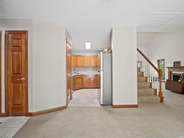 17723 Auburn Rd, Huntertown, IN 46748 - kitchen featuring freestanding refrigerator, light colored carpet, light countertops, light tile patterned floors, and a textured ceiling