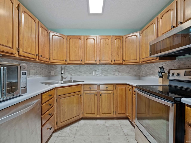17723 Auburn Rd, Huntertown, IN 46748 - kitchen featuring stainless steel appliances, light countertops, light tile patterned floors, decorative backsplash, and a textured ceiling