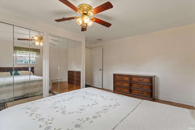 115 N Varsity Dr, South Bend, IN 46615 - tiled bedroom featuring multiple closets, baseboard heating, and ceiling fan