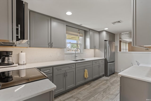 115 N Varsity Dr, South Bend, IN 46615 - kitchen with freestanding refrigerator, gray cabinetry, decorative backsplash, light wood finished floors, and recessed lighting