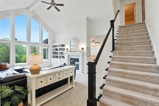 12733 Covington Manor Farms Rd, Fort Wayne, IN 46814 - living area with a ceiling fan, high vaulted ceiling, a glass covered fireplace, stairway, and light carpet