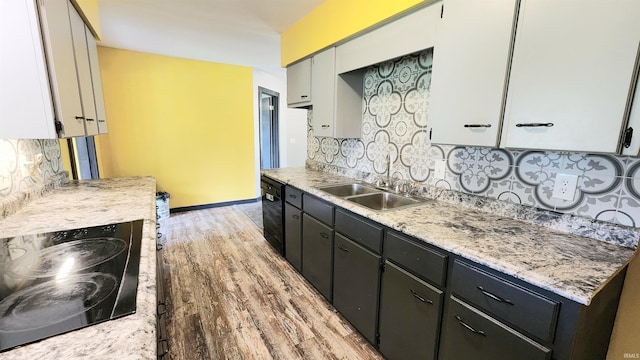 406 James St, Butler, IN 46721 - kitchen with light wood-style flooring, light countertops, tasteful backsplash, and black appliances
