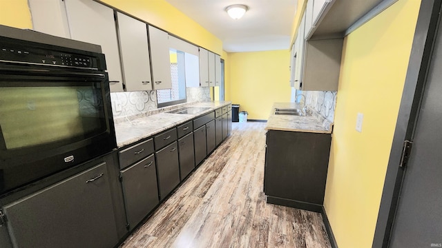 406 James St, Butler, IN 46721 - kitchen featuring black appliances, light wood-style flooring, tasteful backsplash, and light countertops