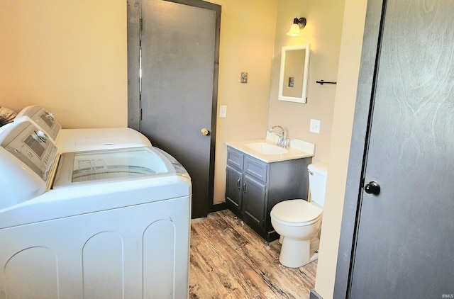 406 James St, Butler, IN 46721 - bathroom featuring washing machine and clothes dryer, wood finished floors, and vanity