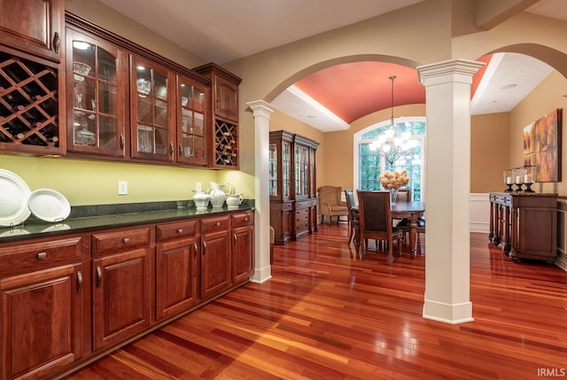 3104 E Chase Ln, Bloomington, IN 47401 - indoor dry bar with arched walkways, decorative columns, wood finished floors, a chandelier, and hanging light fixtures