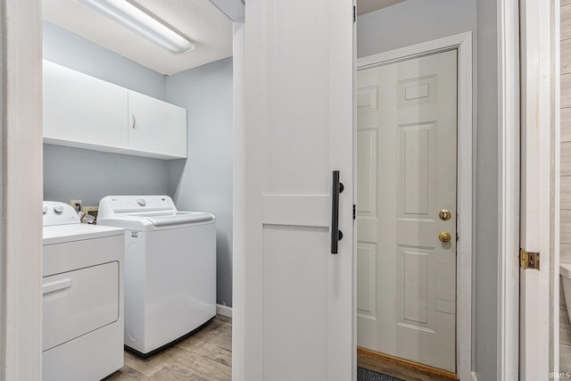 51790 Sulkey Ct, Granger, IN 46530 - laundry room featuring washing machine and clothes dryer, light wood-style flooring, and cabinet space