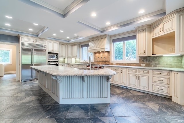 3328 Tarrant Springs Trl, Fort Wayne, IN 46804 - kitchen with built in appliances, cream cabinetry, ornamental molding, custom exhaust hood, and a center island with sink