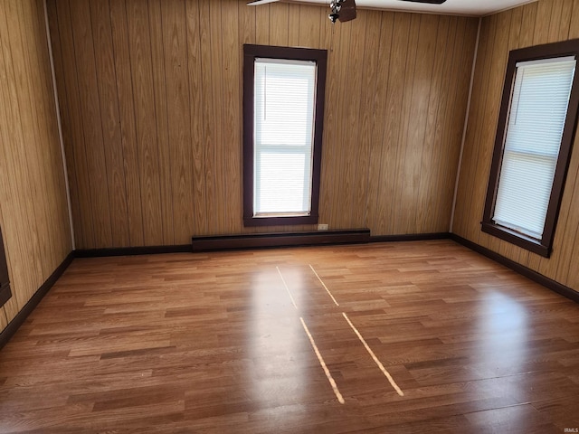 317 E Main St, Berne, IN 46711 - unfurnished room featuring a baseboard radiator, wood finished floors, and wood walls