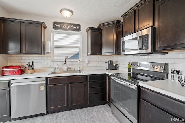 938 Sand Walk Ln, Kokomo, IN 46902 - kitchen featuring stainless steel appliances, light countertops, dark brown cabinetry, and tasteful backsplash
