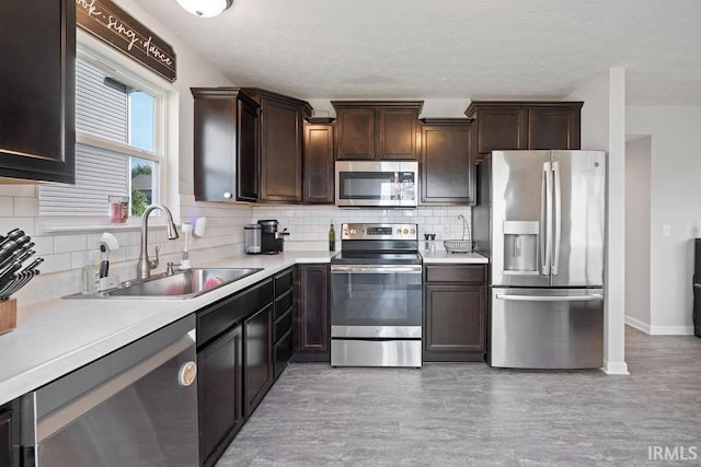 938 Sand Walk Ln, Kokomo, IN 46902 - kitchen featuring appliances with stainless steel finishes, dark brown cabinets, backsplash, light countertops, and a textured ceiling