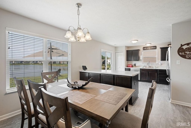938 Sand Walk Ln, Kokomo, IN 46902 - dining area featuring a chandelier, light wood-type flooring, and plenty of natural light
