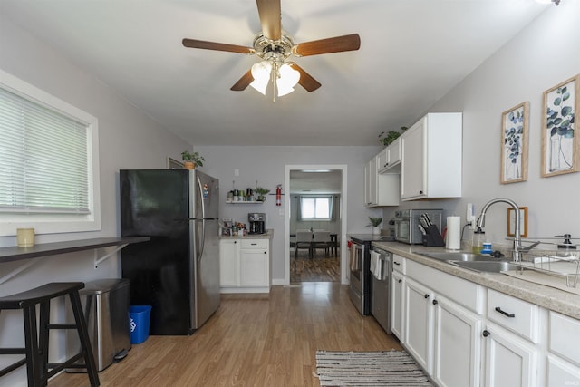 3623 Rexford Dr, South Bend, IN 46615 - kitchen featuring stainless steel appliances, light wood-style flooring, a ceiling fan, white cabinets, and light countertops
