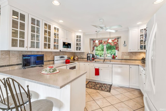 106 River Cove Ln, North Manchester, IN 46962 - kitchen featuring white appliances, a peninsula, decorative backsplash, a ceiling fan, and a breakfast bar area