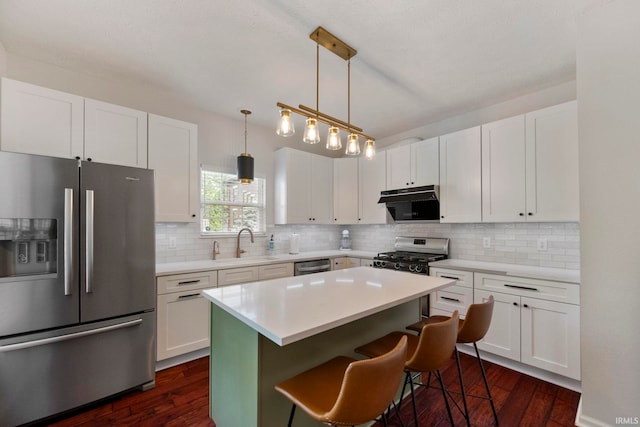 1009 Elliott St, Lafayette, IN 47905 - kitchen with appliances with stainless steel finishes, under cabinet range hood, dark wood-style flooring, and white cabinets