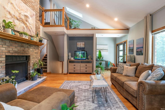 5549 S Tammany Ct, Bloomington, IN 47401 - living area featuring wood finished floors, a skylight, a fireplace, and high vaulted ceiling