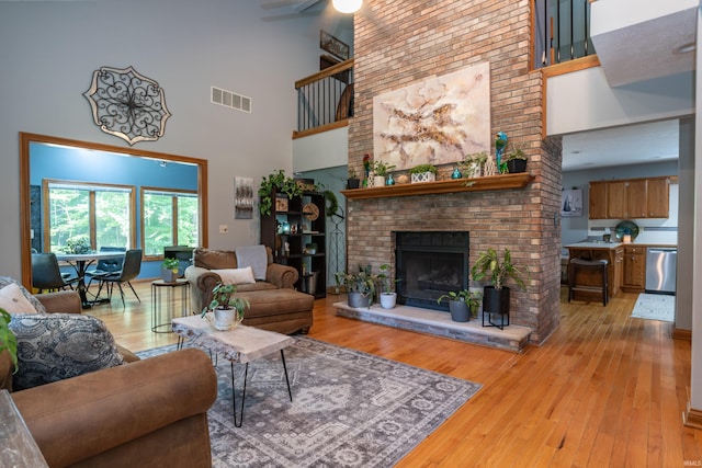 5549 S Tammany Ct, Bloomington, IN 47401 - living room with a high ceiling, light wood-type flooring, a fireplace, and a ceiling fan