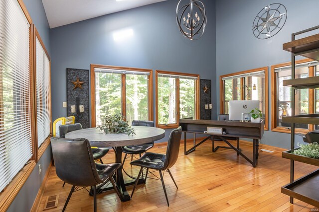 5549 S Tammany Ct, Bloomington, IN 47401 - dining area featuring a towering ceiling, light wood finished floors, a chandelier, and plenty of natural light