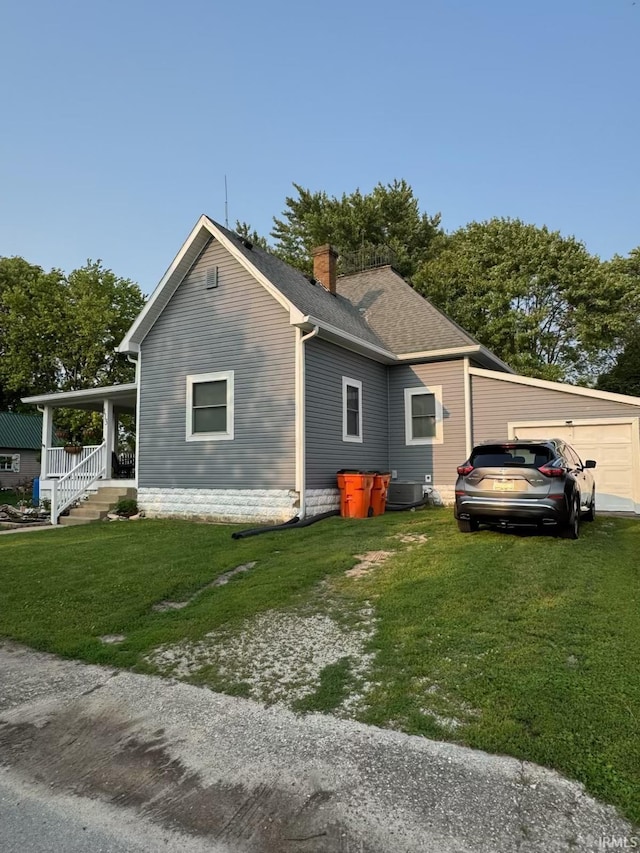 115 N Posey St, Windfall, IN 46076 - view of home's exterior featuring a lawn, a chimney, and a garage