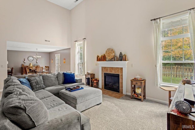 4103 Stergen Dr, Lafayette, IN 47909 - carpeted living room with a chandelier, a tile fireplace, and a towering ceiling