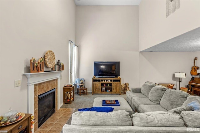 4103 Stergen Dr, Lafayette, IN 47909 - living area featuring a tiled fireplace, a towering ceiling, and light colored carpet