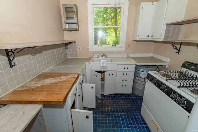 302 C St, Laporte, IN 46350 - kitchen featuring white range with gas stovetop, decorative backsplash, white cabinets, light countertops, and open shelves