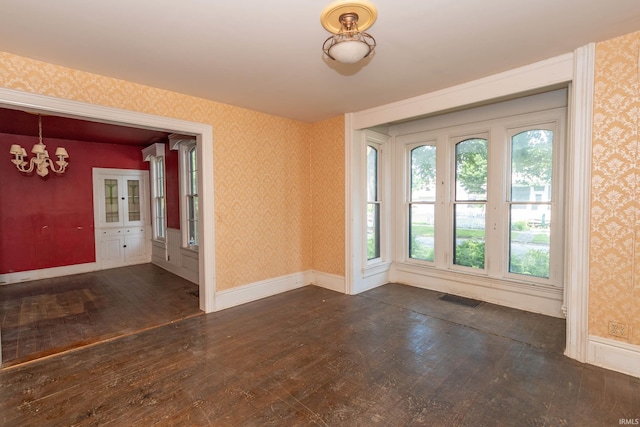 302 C St, Laporte, IN 46350 - empty room featuring dark wood-type flooring, a chandelier, and wallpapered walls