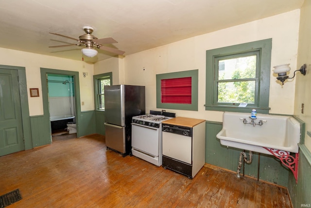 302 C St, Laporte, IN 46350 - kitchen with white appliances, wood finished floors, ceiling fan, and wainscoting