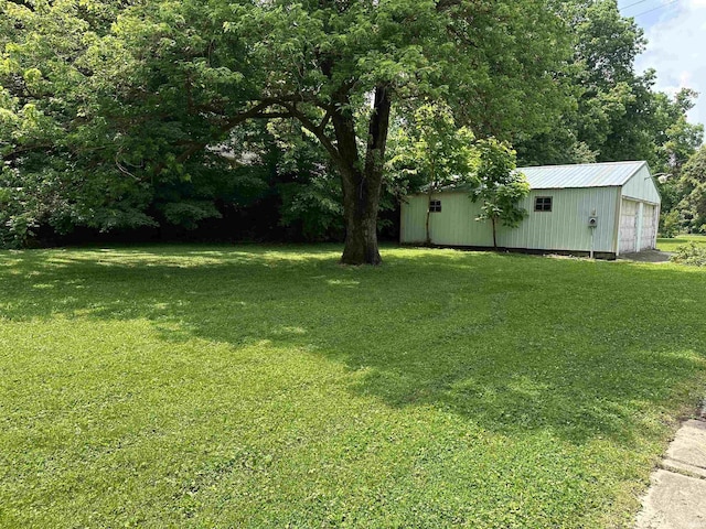 709 W Main St, Ellettsville, IN 47429 - view of green lawn featuring an outdoor structure, a garage, and an outbuilding
