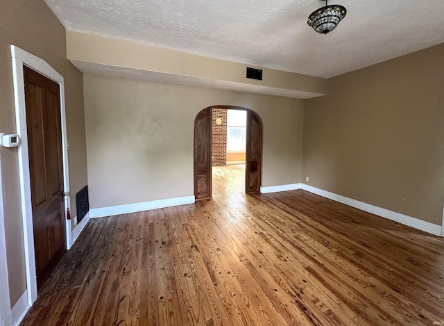 709 W Main St, Ellettsville, IN 47429 - spare room featuring arched walkways, wood finished floors, and a textured ceiling
