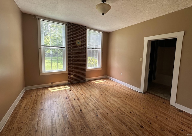 709 W Main St, Ellettsville, IN 47429 - empty room with a textured ceiling, hardwood / wood-style floors, and plenty of natural light