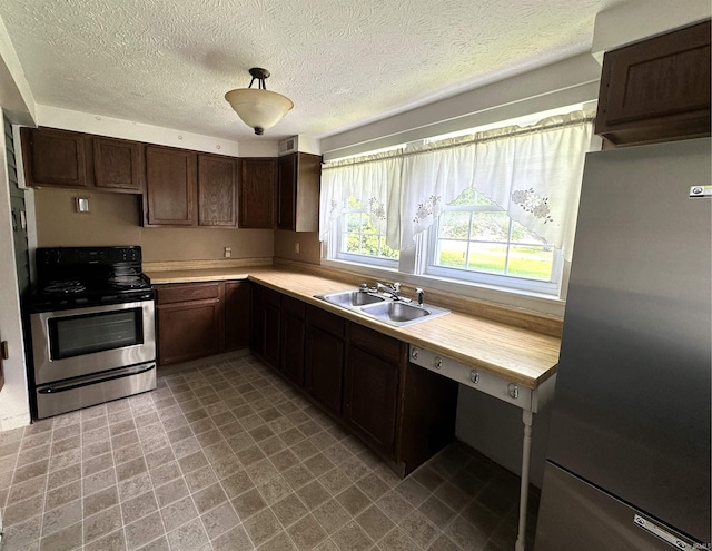 709 W Main St, Ellettsville, IN 47429 - kitchen with appliances with stainless steel finishes, light countertops, a textured ceiling, and dark brown cabinetry