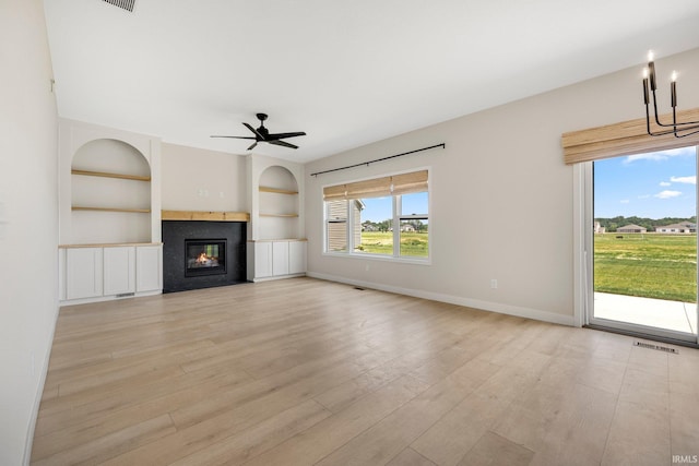 17464 Sonic Ct, Huntertown, IN 46748 - unfurnished living room featuring built in shelves, a glass covered fireplace, light wood finished floors, and a ceiling fan