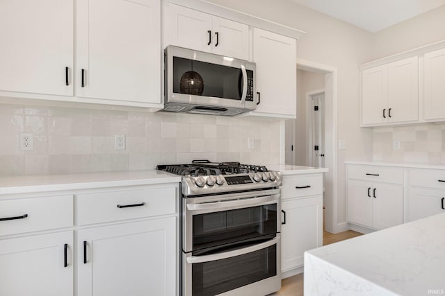 17464 Sonic Ct, Huntertown, IN 46748 - kitchen featuring appliances with stainless steel finishes, white cabinetry, and backsplash