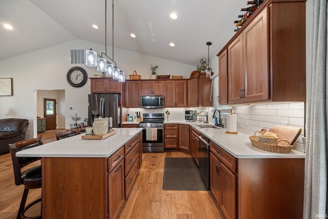 502 N Jefferson Ave, Fowler, IN 47944 - kitchen with appliances with stainless steel finishes, lofted ceiling, light wood-style flooring, a breakfast bar, and light countertops