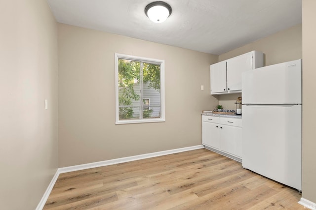 6031 S Calhoun St, Fort Wayne, IN 46803 - kitchen with freestanding refrigerator, light wood-style flooring, white cabinets, and light countertops