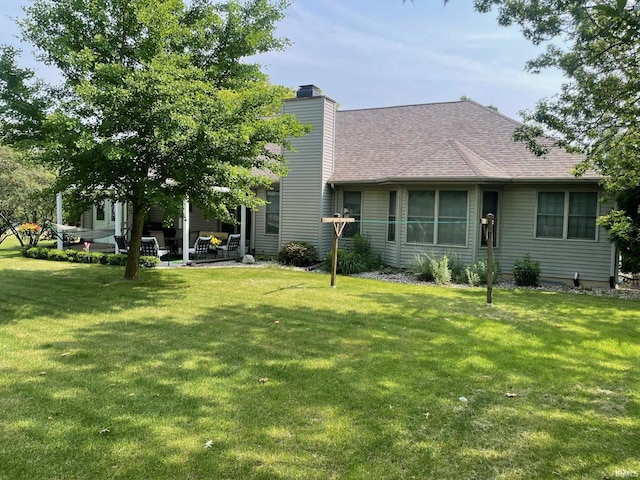 12344 Diamond Dr, Plymouth, IN 46563 - rear view of house with a chimney, a lawn, a shingled roof, and a patio area
