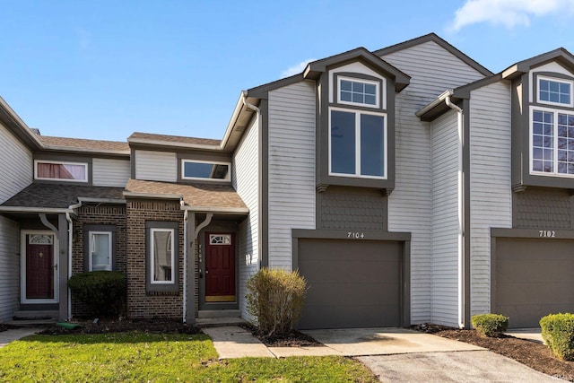 7104 Thamesford Dr Unit 83, Fort Wayne, IN 46835 - townhome / multi-family property with an attached garage, driveway, a shingled roof, and brick siding