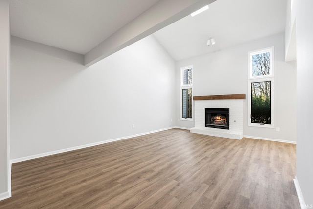 7104 Thamesford Dr Unit 83, Fort Wayne, IN 46835 - unfurnished living room featuring wood finished floors, lofted ceiling, and a brick fireplace