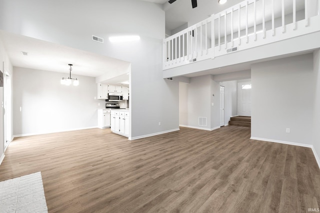 7104 Thamesford Dr Unit 83, Fort Wayne, IN 46835 - unfurnished living room featuring light wood finished floors, a high ceiling, a chandelier, and ceiling fan