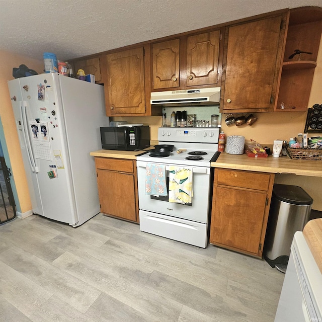 989 S Cataract Rd, Spencer, IN 47460 - kitchen with white appliances, under cabinet range hood, light countertops, light wood-style flooring, and brown cabinets